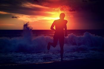 Man running on the beach at sunset