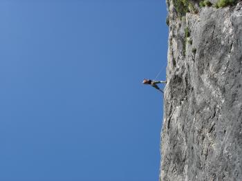 Man Standing on Rock Against Clear Blue Sky