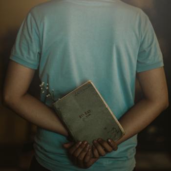 Man Wearing T-shirt Holding Book
