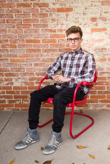 Man Wearing White And Red Long Sleeve Shirt Sitting On Red Steel Armchair