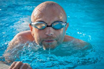 Man With Gray Swimming Goggles in Body of Water