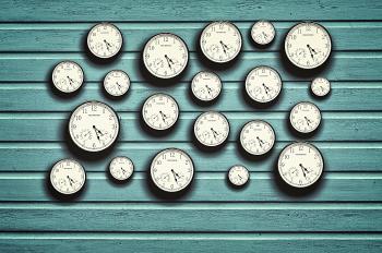 Many clocks in a blue wooden background