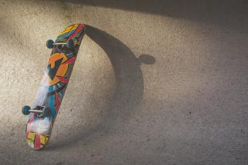 Multicolored Skateboard Leaning on Wall