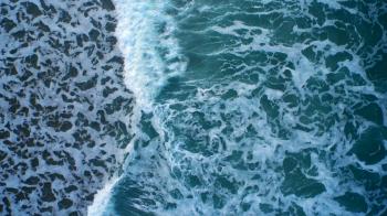 Aerial drone video of ocean waves crashing on shore. As the waves ...