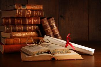 Pile of old books with glasses on desk - Martine Robertson - Homeopath