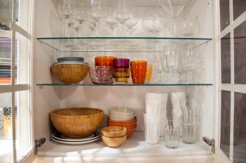 Opened cupboard with kitchenware inside