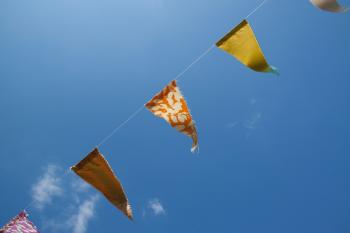 Orange Yellow and Red Flaglets Under Blue White Sky during Daytime