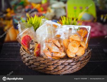 Plastic disposable containers with cookies and pastries in a wicker ...