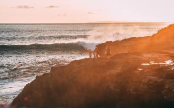 People Standing on Cliff Near Body of Water Golden Hour Photography