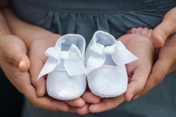 Person Carrying Pair of Baby's White Flats