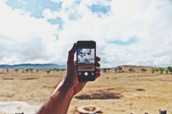 Person Holding Smartphone Showing Cloudy Sky