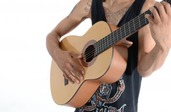 Person in Black Tank Top Playing Acoustic Guitar