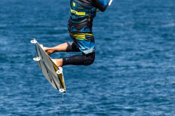 Person in Blue and Black Board Shorts on White Wake Board