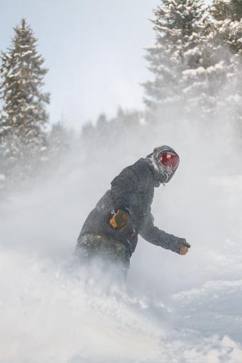 Person in Grey Jacket and Red Snow Goggles Riding on Snowboard