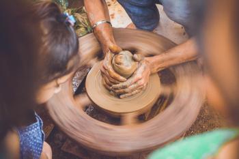 Person Making Clay Pot in Front of Girl during Daytime