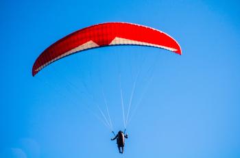 Person Using Red Parachute on Mid Air
