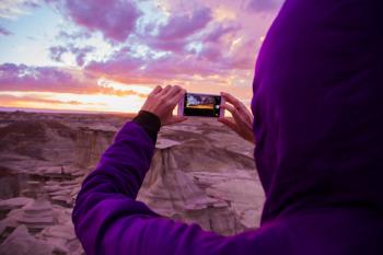 Person Wearing Purple Hoodie Jacket Holding Iphone 6 during Golden Hour
