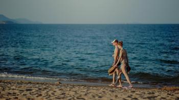 Photo of Man and Woman Walking on Seashore