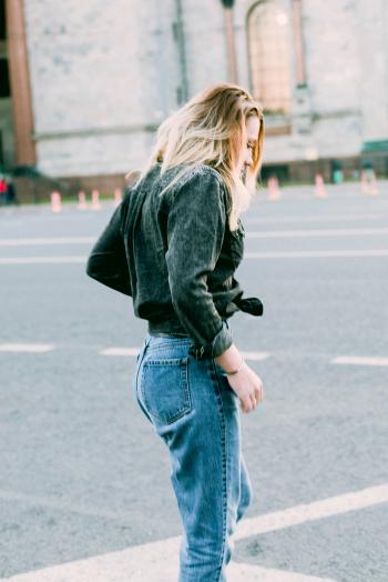 Photo of Woman Wearing Black Denim Jacket and Blue Jeans