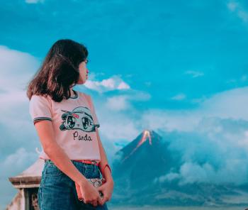 Photography of a Girl In Front of Erupting Volcano