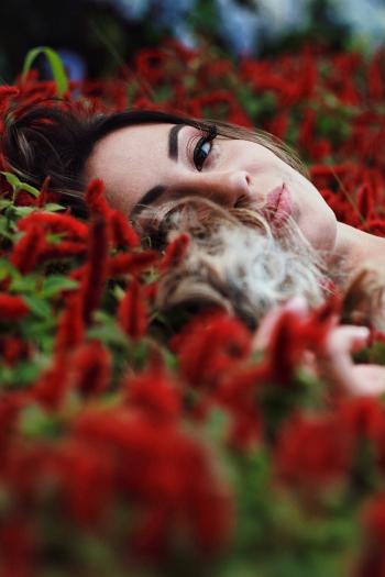 Photography of a Woman Lying on Flowers