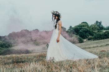 Photography Of Woman In White Wedding Dress Walking On Grass Field