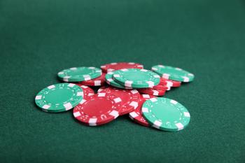 Pile of poker chips on green felt.