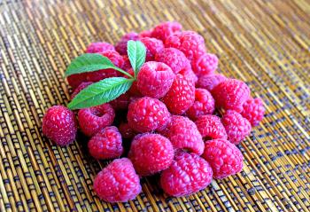 Raspberries on the table with leaves