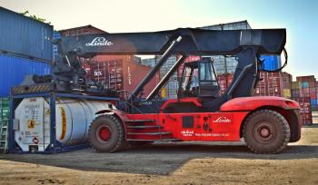 Red and Black Front-loader Beside Intermodal Containers