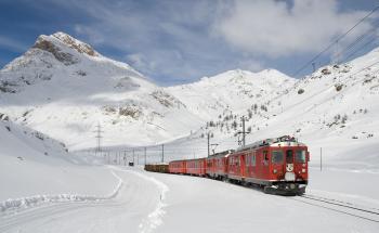 Red and Black Train Running Along Snow Covered Field