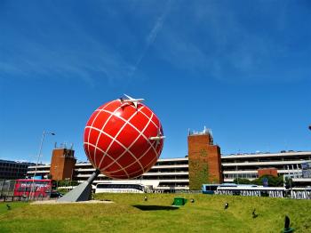 Red and White Globe Statue Near Brown and White Concrete Building