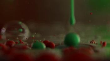 Opaque red bubbles float in clear gel, and green gel is squeezed in ...