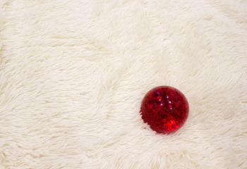 red glass ball on white fur