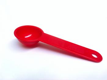 Red plastic measuring teaspoon