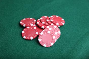Red poker chips on green felt.