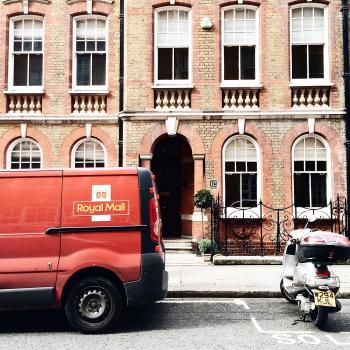 Red Royal Mail Parked Near Brown Brick Building