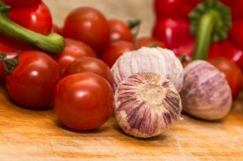Red Tomatoes Beside Red Onions on Brown Wooden Table