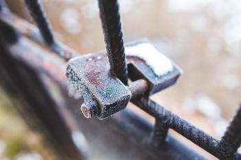 Rusty padlock covered with hoarfrost ice crystals