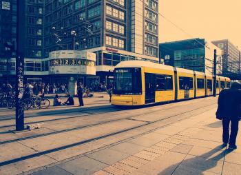 Selective Color Photography of Yellow Train Near Concrete Buildings