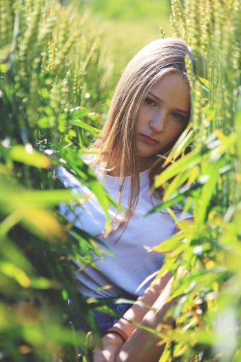 Selective Focus Photo of Woman Wearing White Shirt Between Green Wheat