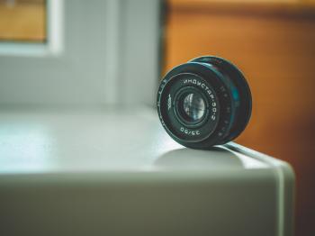 Selective Focus Photography of Black Telephoto Lens on White Table