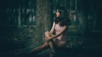 Selective Focus Photography of Woman Wearing Pink Dress Sitting on Tree Roots
