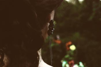 Selective Focus Photography of Woman's Back With Black Pendant Earrings