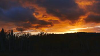 Time lapse-Brilliant setting sun lights rapidly moving dark ominous ...