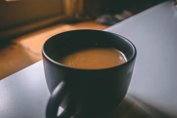 Shallow Focus Photography of Black Ceramic Mug Filled With Brown Coffee on the Table