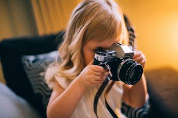 Shallow Focus Photography of Girl Holding a Black and Silver Dslr Camera