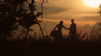 Silhouette of Young Married Couple Dancing In The Field On The ...
