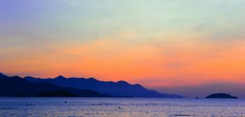 Silhouette of Mountain Beside Ocean during Orange Sunset