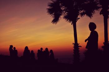 Silhouette of People Standing Under Orange Sky