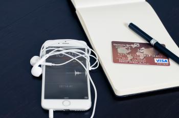 Silver Iphone 6 Beside Red Visa Card